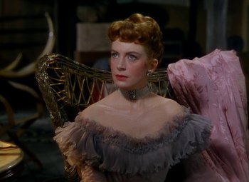 Movie still from “King Solomon's Mines” (1950), directed by Andrew Marton – A woman in a dress sitting in a chair; Close Up shot, Over the shoulder angle