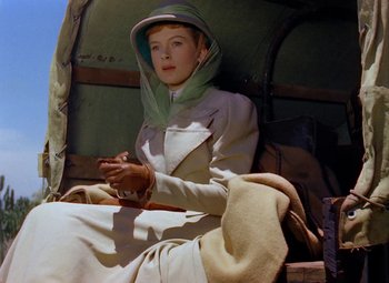 Movie still from “King Solomon's Mines” (1950), directed by Andrew Marton – A woman sitting on a chair wearing a hood; Medium shot, Low angle