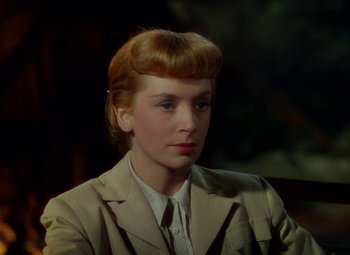 Movie still from “King Solomon's Mines” (1950), directed by Andrew Marton – A woman in a tan jacket is sitting in a chair; Close Up shot, Over the shoulder angle