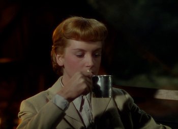 Movie still from “King Solomon's Mines” (1950), directed by Andrew Marton – A woman in a suit drinking from a metal cup; Close Up shot, High angle
