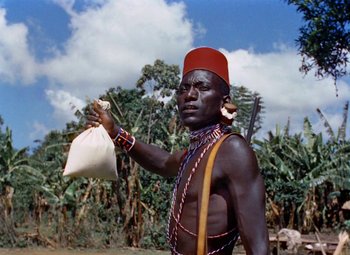 Movie still from “King Solomon's Mines” (1950), directed by Andrew Marton – A man holding a white bag in his hand; Medium shot, Low angle