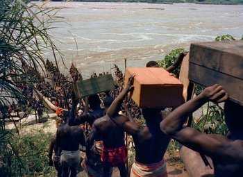 Movie still from “King Solomon's Mines” (1950), directed by Andrew Marton – A group of men carrying boxes on their heads; Extreme Wide shot, High angle