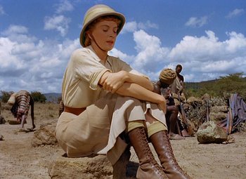 Movie still from “King Solomon's Mines” (1950), directed by Andrew Marton – A woman sitting on a rock in the desert; Wide shot, Low angle