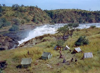 Movie still from “King Solomon's Mines” (1950), directed by Andrew Marton – A group of tents in the grass near a river; Extreme Wide shot, High angle