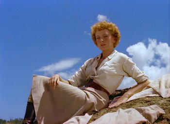 Movie still from “King Solomon's Mines” (1950), directed by Andrew Marton – A woman sitting on top of a hill in front of a sky background; Medium shot, Low angle