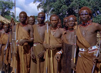 Movie still from “King Solomon's Mines” (1950), directed by Andrew Marton – A group of men standing next to each other holding sticks; Medium shot, Low angle