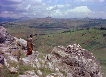 Movie still from “King Solomon's Mines” (1950), directed by Andrew Marton – A man standing on top of a mountain holding a stick; Extreme Wide shot, High angle