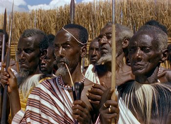 Movie still from “King Solomon's Mines” (1950), directed by Andrew Marton – A group of men standing next to each other holding spears; Close Up shot, High angle