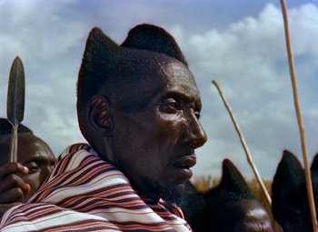 Movie still from “King Solomon's Mines” (1950), directed by Andrew Marton – A man with a very long black hair and a striped shirt; Close Up shot, Low angle