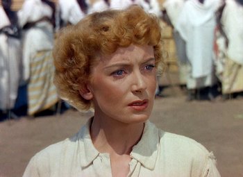 Movie still from “King Solomon's Mines” (1950), directed by Andrew Marton – An older woman with blonde curly hair and blue eyes; Close Up shot, Over the shoulder angle