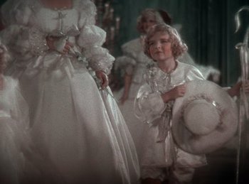 Movie still from “King of Jazz” (1930), directed by Walter Lantz – A little girl in a white dress holding a white hat; Medium shot, High angle