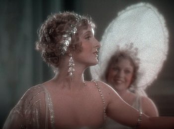 Movie still from “King of Jazz” (1930), directed by Walter Lantz – A woman in a white dress with a white parasol in front of a mirror; Close Up shot, Over the shoulder angle