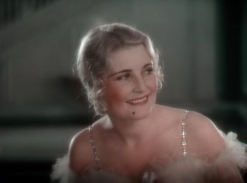 Movie still from “King of Jazz” (1930), directed by Walter Lantz – An old photo of a beautiful woman in a white dress; Close Up shot, High angle