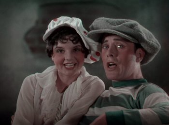 Movie still from “King of Jazz” (1930), directed by Walter Lantz – A man and a woman are posing for a picture; Medium shot, Low angle