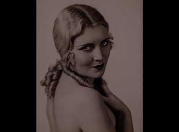 Movie still from “King of Jazz” (1930), directed by Walter Lantz – An old photograph of a woman with a braid; Close Up shot, High angle