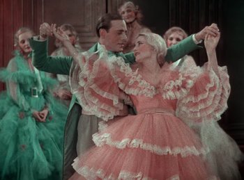 Movie still from “King of Jazz” (1930), directed by Walter Lantz – A man and a woman dressed in a pink dress; Medium shot, Low angle