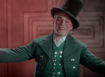 Movie still from “King of Jazz” (1930), directed by Walter Lantz – A man wearing a green suit and a top hat; Medium shot, Low angle