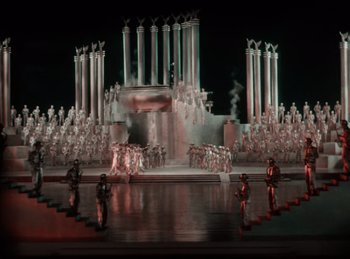 Movie still from “King of Jazz” (1930), directed by Walter Lantz – A group of people standing in front of a stage; Extreme Wide shot, High angle
