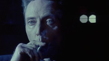 Movie still from “King of New York” (1990), directed by Abel Ferrara – A person smoking a cigarette; Close Up shot, Low angle