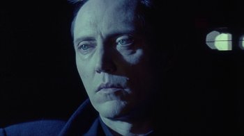 Movie still from “King of New York” (1990), directed by Abel Ferrara – A person wearing a suit and tie; Close Up shot, Low angle