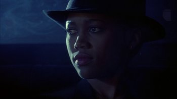Movie still from “King of New York” (1990), directed by Abel Ferrara – A woman wearing a black hat looking to her left; Close Up shot, Low angle