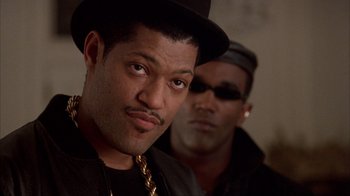 Movie still from “King of New York” (1990), directed by Abel Ferrara – A man in a black hat and a man in a black jacket; Close Up shot, Low angle