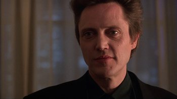 Movie still from “King of New York” (1990), directed by Abel Ferrara – A person wearing a suit and tie; Close Up shot, Low angle