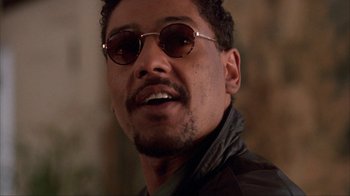 Movie still from “King of New York” (1990), directed by Abel Ferrara – A person wearing sunglasses and a jacket; Close Up shot, Low angle