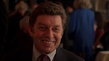 Movie still from “King of New York” (1990), directed by Abel Ferrara – A person wearing a suit and tie; Close Up shot, Low angle