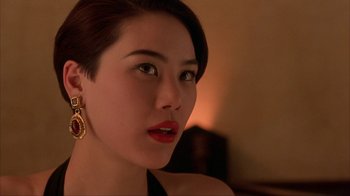 Movie still from “King of New York” (1990), directed by Abel Ferrara – A beautiful woman with red lipstick wearing a black dress; Close Up shot, Over the shoulder angle