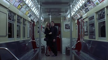 Movie still from “King of New York” (1990), directed by Abel Ferrara – A man and a woman standing on a subway train; Wide shot, Low angle