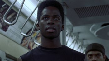 Movie still from “King of New York” (1990), directed by Abel Ferrara – A man with a black shirt is standing on a train; Close Up shot, Low angle