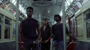 Movie still from “King of New York” (1990), directed by Abel Ferrara – A group of men standing on a subway train; Medium shot, Low angle