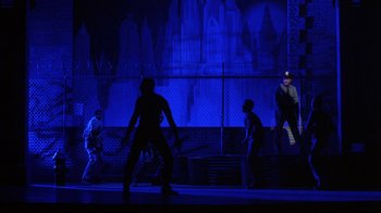 Movie still from “King of New York” (1990), directed by Abel Ferrara – A group of people standing on top of a stage; Extreme Wide shot, Low angle