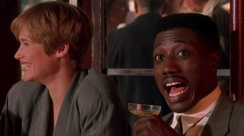 Movie still from “King of New York” (1990), directed by Abel Ferrara – A person holding a glass of wine; Close Up shot, Over the shoulder angle