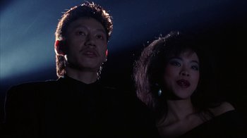 Movie still from “King of New York” (1990), directed by Abel Ferrara – A man and a woman standing next to each other in the dark; Close Up shot, Low angle