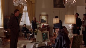 Movie still from “King of New York” (1990), directed by Abel Ferrara – A group of people sitting in a living room; Wide shot, Low angle