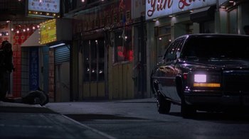 Movie still from “King of New York” (1990), directed by Abel Ferrara – A car parked on the side of the road at night; Wide shot, Low angle
