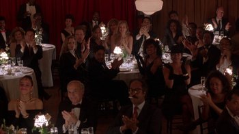 Movie still from “King of New York” (1990), directed by Abel Ferrara – A group of people sitting at a table clapping; Wide shot, High angle
