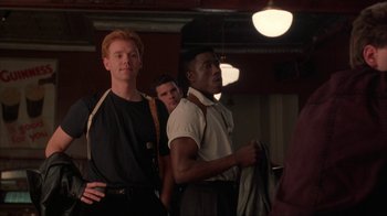 Movie still from “King of New York” (1990), directed by Abel Ferrara – A group of men standing next to each other in a room; Medium shot, Low angle