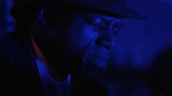 Movie still from “King of New York” (1990), directed by Abel Ferrara – A person wearing a hat in the dark; Close Up shot, Low angle