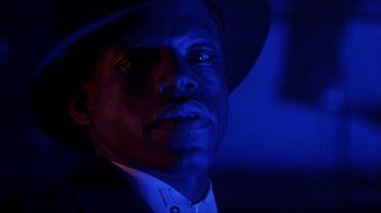 Movie still from “King of New York” (1990), directed by Abel Ferrara – A person wearing a hat; Close Up shot, Low angle