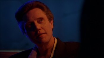 Movie still from “King of New York” (1990), directed by Abel Ferrara – A person wearing a suit and tie; Close Up shot, Low angle