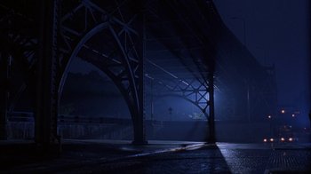 Movie still from “King of New York” (1990), directed by Abel Ferrara – A bridge that has a light shining on it; Extreme Wide shot, Low angle