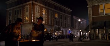 A man in a top hat standing in front of a building