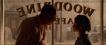 A man and a woman standing in front of a store window