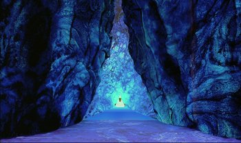 Movie still from “Kirikou and the Sorceress” (1998), directed by Raymond Burlet – A person is sitting in a cave in the middle of the night; Extreme Wide shot, High angle