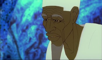 Movie still from “Kirikou and the Sorceress” (1998), directed by Raymond Burlet – An old man with a white turban is looking at the camera; Close Up shot, Low angle