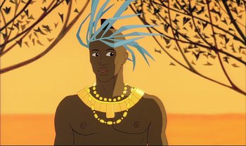 Movie still from “Kirikou and the Sorceress” (1998), directed by Raymond Burlet – An animated man wearing a blue headdress and gold necklace; Close Up shot, Low angle