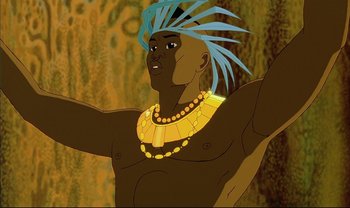 Movie still from “Kirikou and the Sorceress” (1998), directed by Raymond Burlet – An animated man wearing a blue and yellow headdress; Medium shot, Low angle